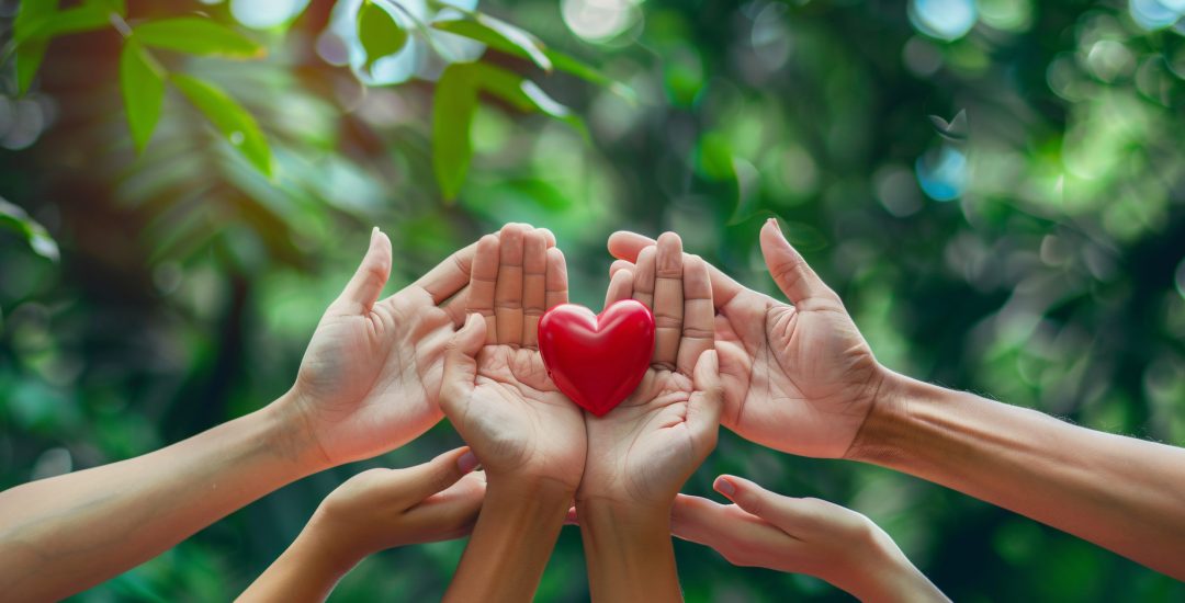 Assisting with open arms for a good cause, showing compassion for others through a heart-shaped emblem, aiding a diverse community with love and care.